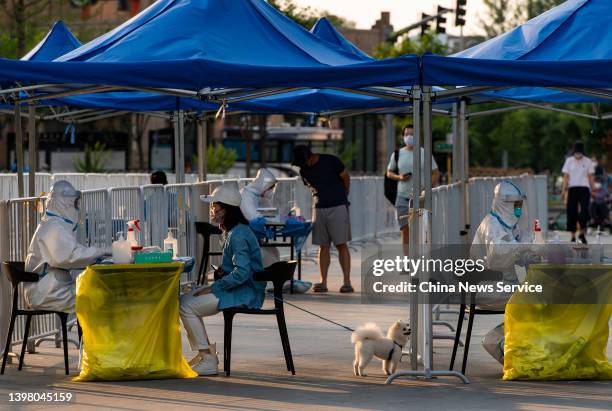 Residents waits to take nucleic acid test at a testing site in Chaoyang district on May 18, 2022 in Beijing, China. Four districts, Xicheng, Haidian,...