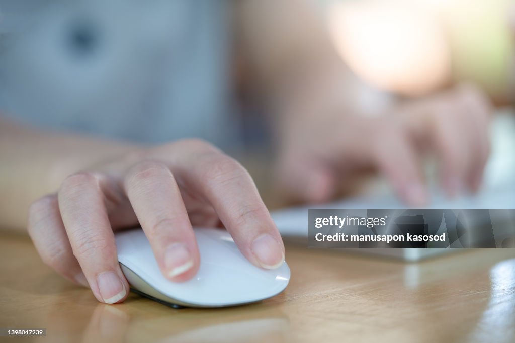 Hands of woman using computer keyboard and mouse