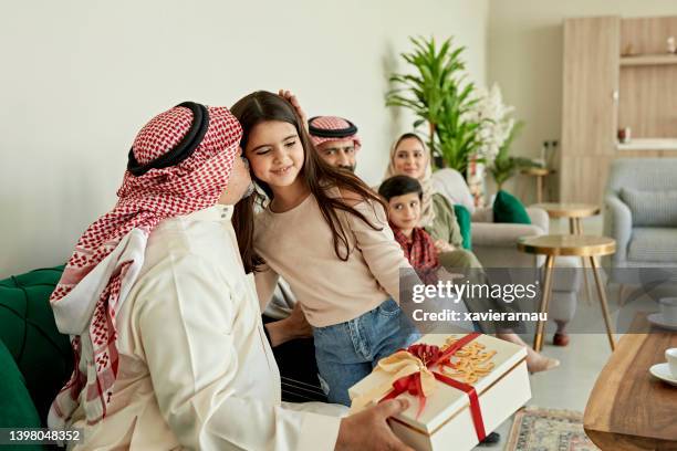 une famille du moyen-orient réunie pour l’échange de cadeaux de l’aïd-ul-fitr - eid ul fitr photos et images de collection