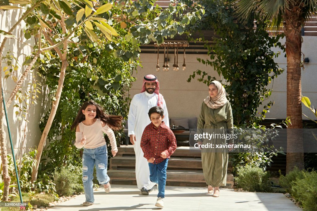 Active Saudi children outdoors with their parents