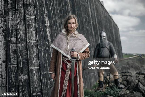 a beautiful blonde viking woman at the village gate - ancient stock pictures, royalty-free photos & images