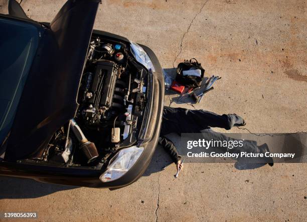 female mechanic working under a car engine outdoors - auto repair shop exterior stock pictures, royalty-free photos & images