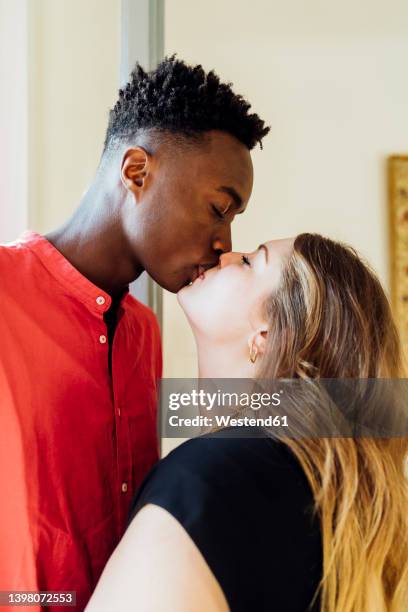 couple with closed eyes kissing each other at home - black women kissing white men - fotografias e filmes do acervo