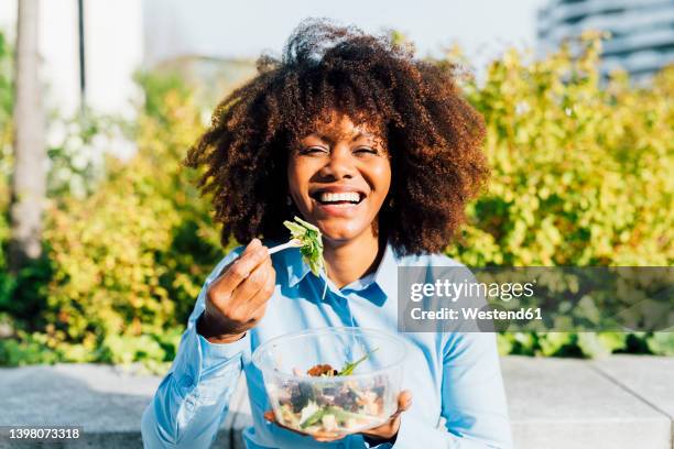 happy businesswoman eating salad on sunny day - lunchpauze stockfoto's en -beelden