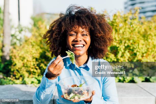 happy businesswoman eating salad on sunny day - healthy food stockfoto's en -beelden