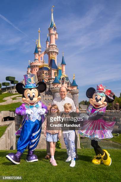 In this handout provided by Disney, Mickey, Princess Gabriella of Monaco, Prince Jacques of Monaco and Minnie pose in front of the Sleeping Beauty...