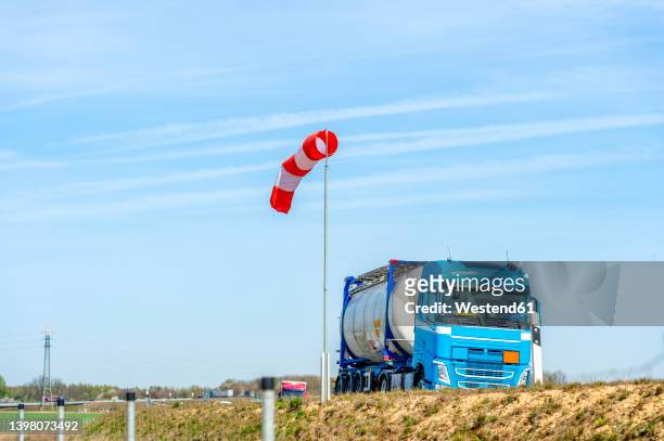 blue fuel truck on motorway in front of windsock - wind sock stock pictures, royalty-free photos & images