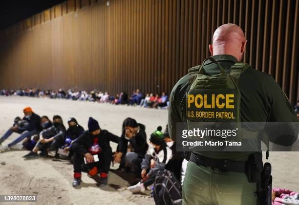 Border Patrol agent checks the passports of immigrants after they crossed the border with Mexico on May 18, 2022 in Yuma, Arizona. Title 42, the...