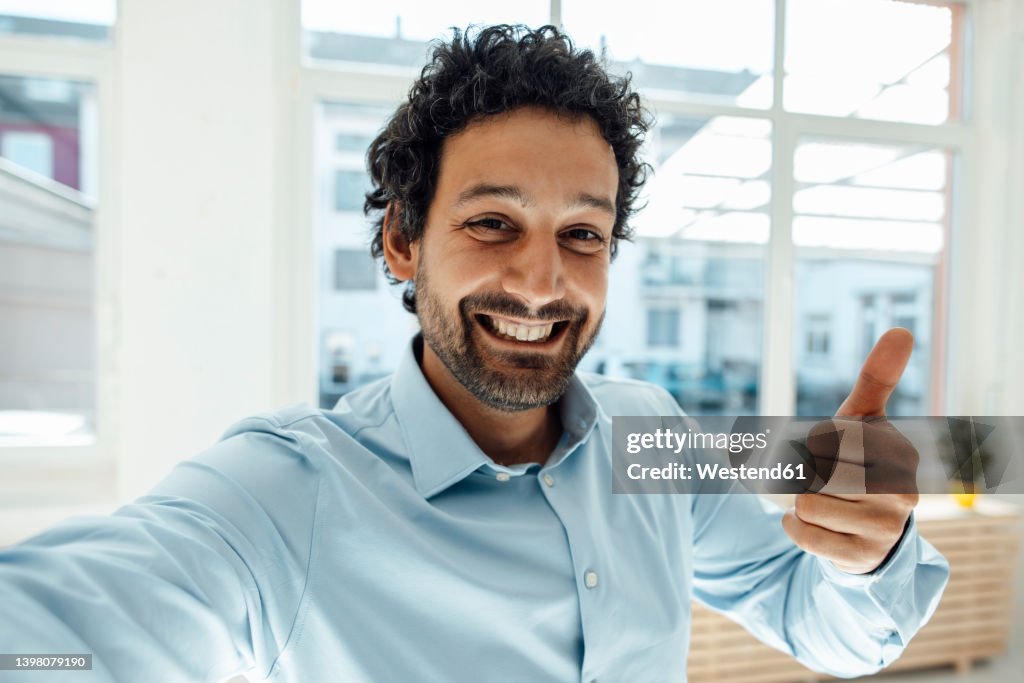 Happy businessman gesturing thumbs up