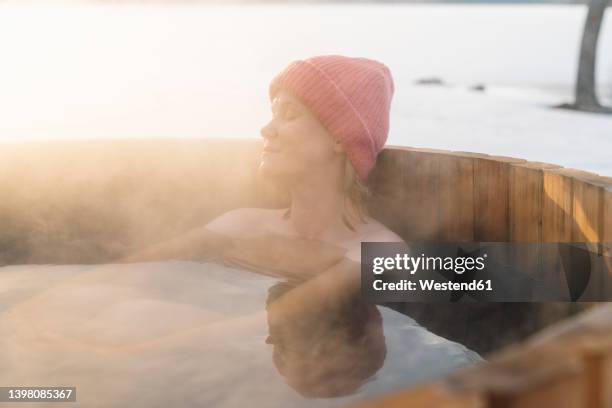 topless woman in knit hat taking hot water bath in winter - bathing stock pictures, royalty-free photos & images