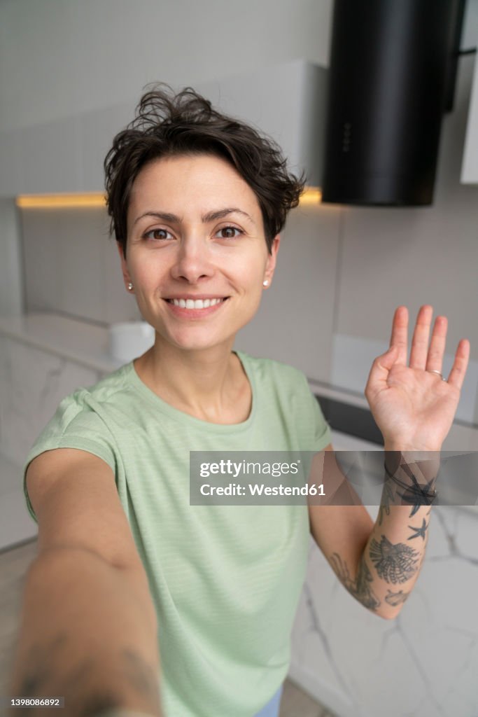Smiling woman taking selfie at home
