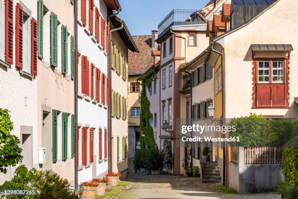 austria, vorarlberg, bregenz, townhouses along empty cobblestone alley - bregenz stock pictures, royalty-free photos & images