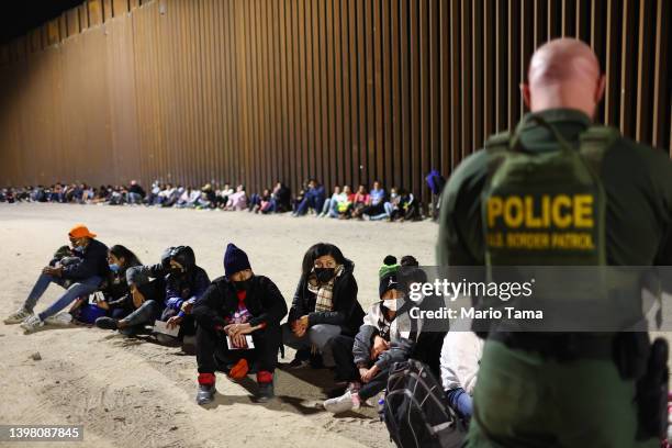 Border Patrol agent checks the passports of immigrants after they crossed the border from Mexico on May 18, 2022 in Yuma, Arizona. Title 42, the...