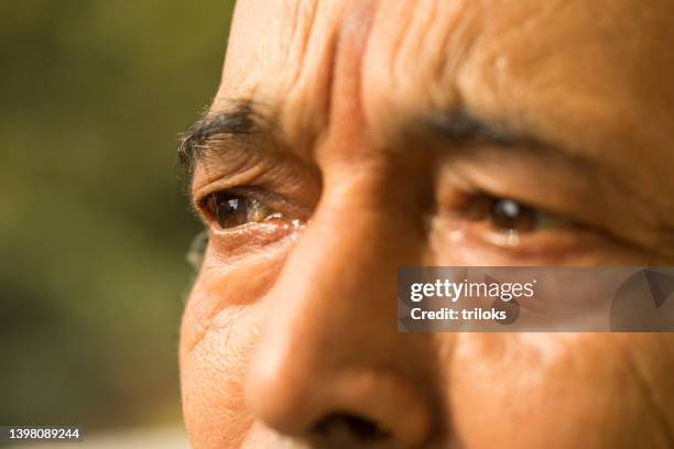 eyes of senior man looking away - teardrop stockfoto's en -beelden
