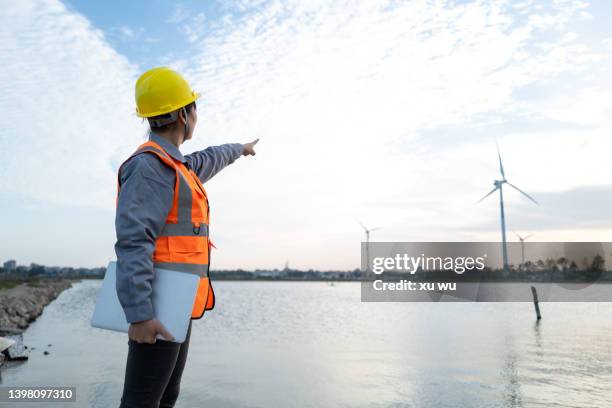 female engineer manager finger in front of wind power station - airboard stock pictures, royalty-free photos & images