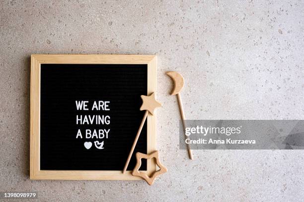 set of baby essentials and a letter board with text “we are having a baby” on concrete background, top view. baby announcement concept. baby expectation. copy space. - ankündigung stock-fotos und bilder