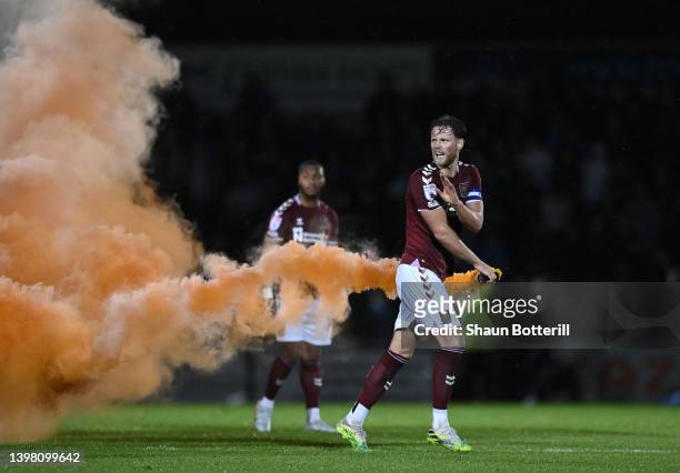 Fraser Horsfall of Northampton Town removes a flare from the pitch during the Sky Bet League Two Play-off Semi Final 2nd Leg match between...