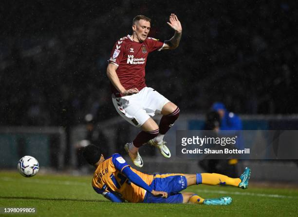 Mitch Pinnock of Northampton Town is tackled by James Perch of Mansfield Town during the Sky Bet League Two Play-off Semi Final 2nd Leg match between...