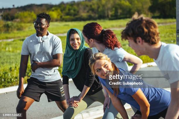 group of multiethnic students laughing after running - teenager yoga stock pictures, royalty-free photos & images