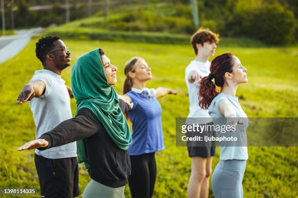 friends standing with their arms outstretched. - teenager yoga stock pictures, royalty-free photos & images