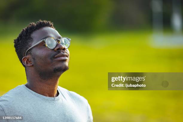 side view of tranquil peaceful adult male in tshirt standing at meadow - deep breathing stock pictures, royalty-free photos & images