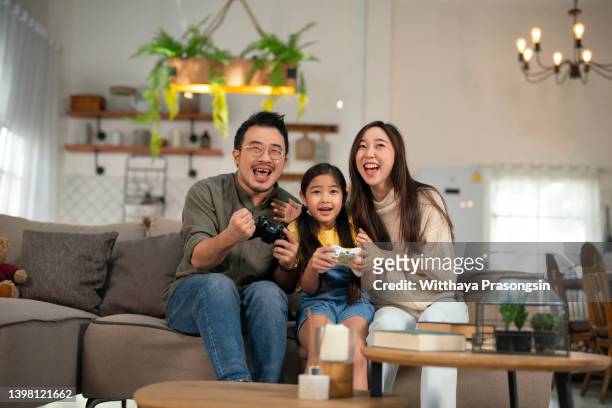 parents spend their free time with their daughters playing games. - asian games day 9 stock-fotos und bilder