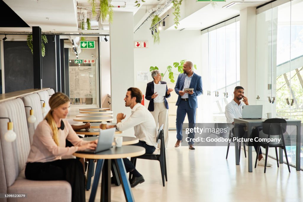 Diverse Geschäftsleute, die im Lounge-Bereich eines Büros arbeiten