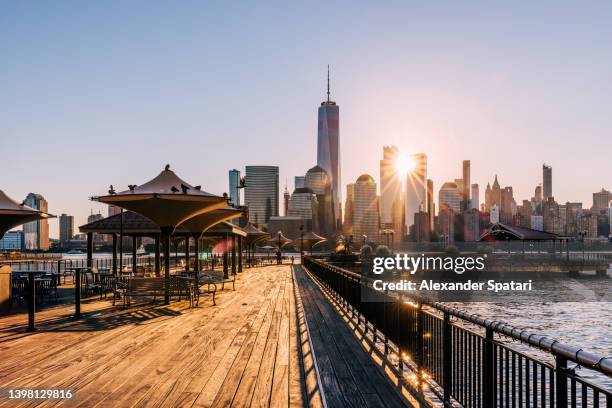 sunrise in new york city seen from the pier in jersey city, usa - jersey city stock-fotos und bilder