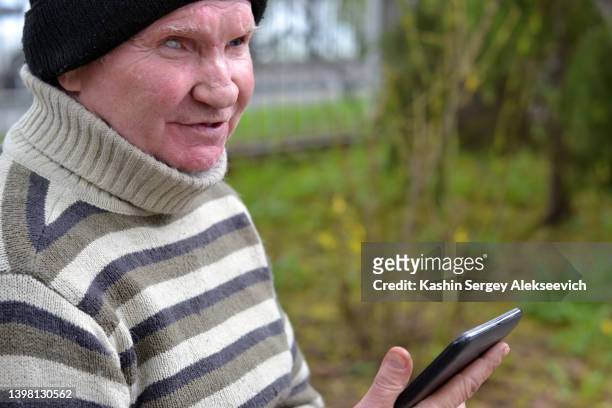 portrait of senior man using smartphone. - one eyed stock pictures, royalty-free photos & images