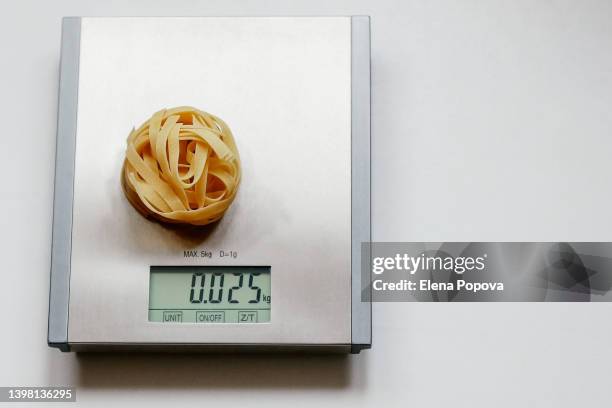 tagliatelle pasta at the kitchen scale - keukenweegschaal stockfoto's en -beelden