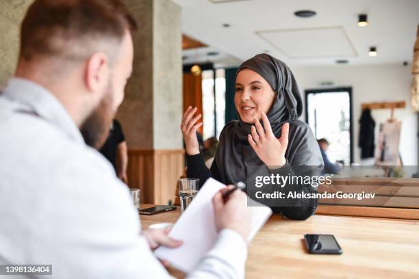 job interview going well for muslim female - serious interview stock pictures, royalty-free photos & images