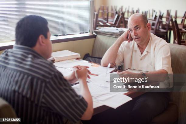 caucasian restaurant owner working with co-worker in booth - co owner - fotografias e filmes do acervo