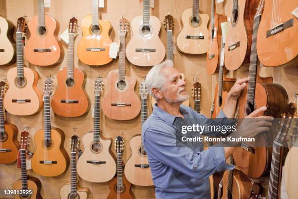 hispanic handwerker hängen gitarre auf wand-shop - large group of craftsman stock-fotos und bilder