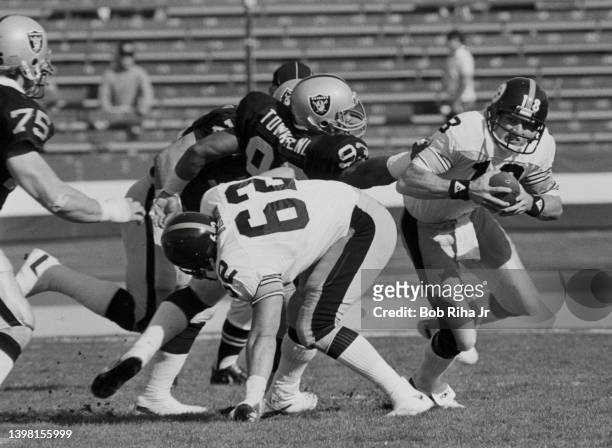 Pittsburgh Steelers QB Cliff Stoudt under heavy pressure from Raiders Howie Long , Lyle Alzado and Greg Townsend during playoff game action against...
