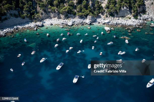 Aerial view, from helicopter, boats in an inlet with a natural beach on the island in the Gulf of Naples on July 14, 2019 in Island of Capri, Italy....