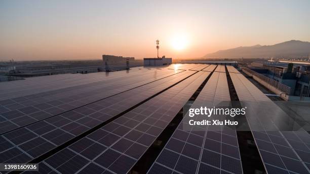 solar panels on city roofs - dach stock-fotos und bilder