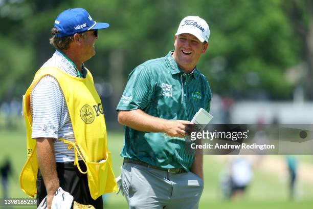 Tom Hoge of the United States and his caddie Henry Diana share a laugh on the 17th green during the first round of the 2022 PGA Championship at...