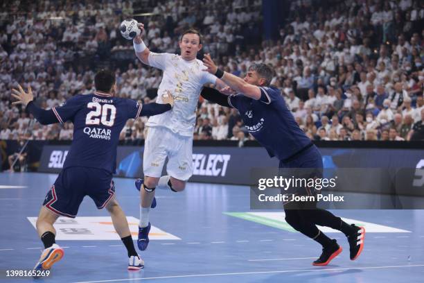 Sander Sagosen of Kiel challenges Mathieu Grebille and Luka Karabatic of Paris during the EHF Champions League quarter final second leg match between...