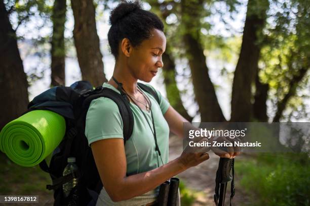 african-american ethnicity woman checking smartwatch - african american hiking stock pictures, royalty-free photos & images