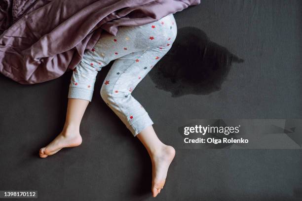 unrecognizable child legs on wet bed. incontinence problem - shameful stock pictures, royalty-free photos & images