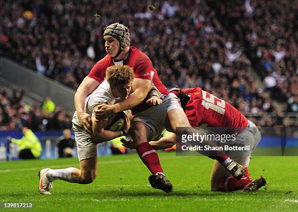 David Strettle of England Jonathan Davies and Leigh Halfpenny of Wales is tackled by as he crosses the try line, but the try is not given during the...