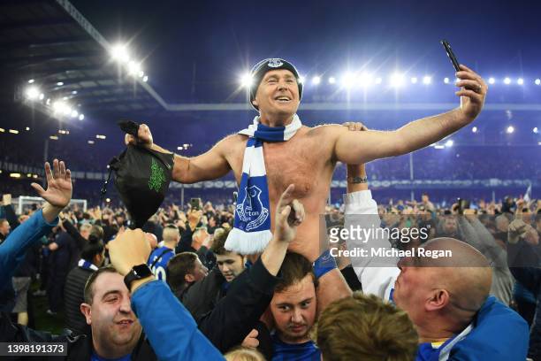 Everton fans celebrate on the pitch following their sides victory as they avoid relegation after the Premier League match between Everton and Crystal...