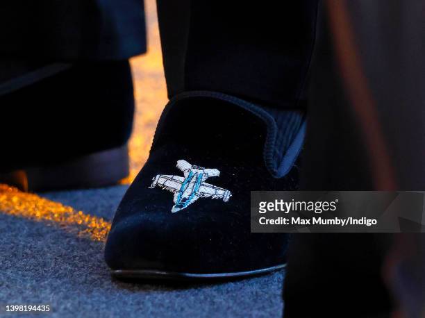 Prince William, Duke of Cambridge, wearing a pair of velvet evening slippers embroidered with a fighter plane design, attends the UK premiere and...