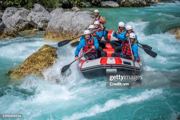 wildwasser-team-adrenalin-aktivität, paddeln durch stromschnellen um große steine - rafting stock-fotos und bilder
