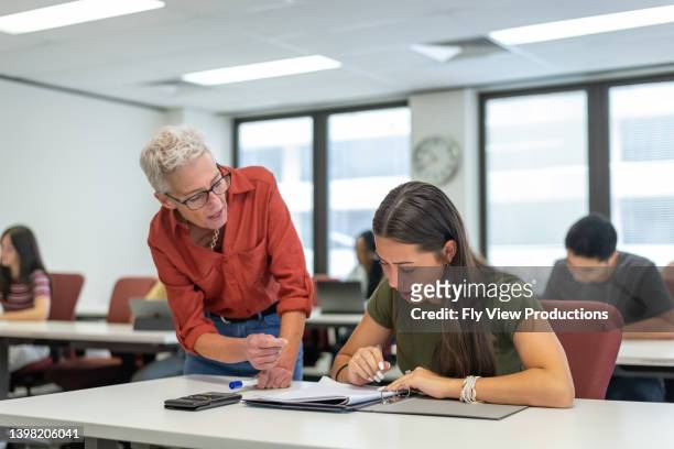 teacher helping high school student during class - student high school stock pictures, royalty-free photos & images