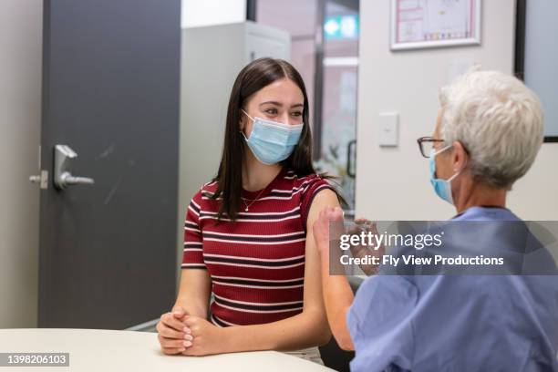 teenage girl getting vaccination injection - aussie flu stock pictures, royalty-free photos & images