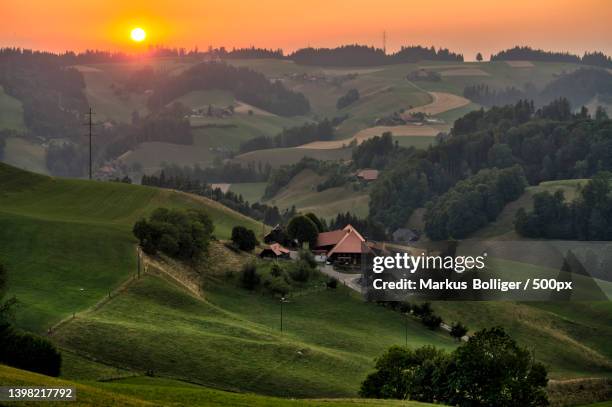 scenic view of agricultural field against sky during sunset,switzerland - gewitterwolken stockfoto's en -beelden