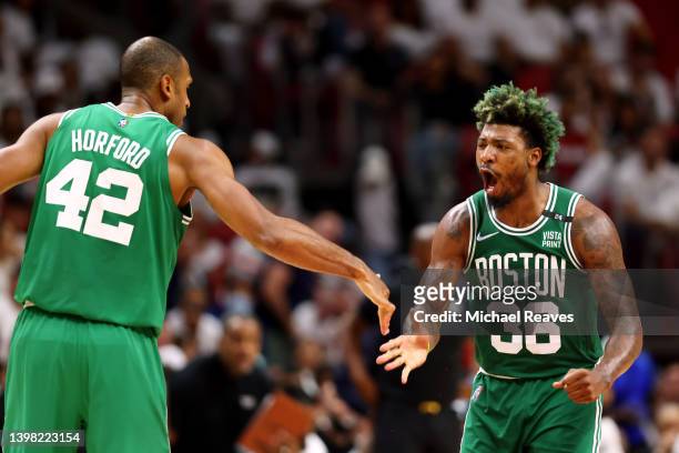 Marcus Smart of the Boston Celtics celebrates a three point basket with teammate Al Horford during the fourth quarter against the Miami Heat in Game...