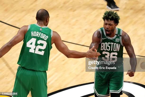 Marcus Smart of the Boston Celtics celebrates a three point basket with teammate Al Horford during the fourth quarter against the Miami Heat in Game...