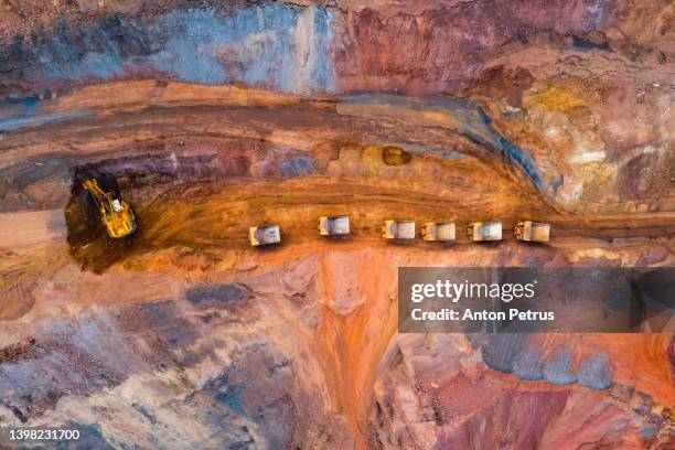 aerial view of open pit iron ore and heavy mining equipment. large excavator - mining stock pictures, royalty-free photos & images